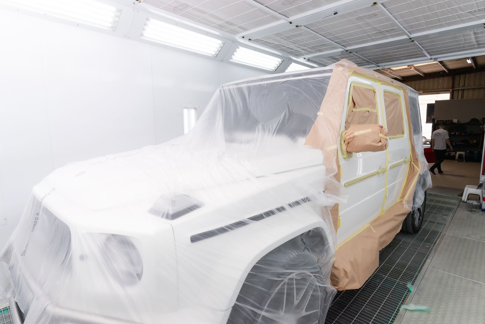 Vehicle masked and prepared for body paint repair in professional spray booth